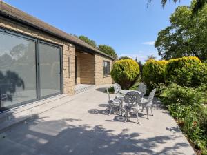une terrasse avec une table et des chaises dans une maison dans l'établissement Rose Cottage, à Alnwick