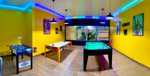 a room with two tables and a ping pong table at Carlton Plaza Baobá in Taubaté