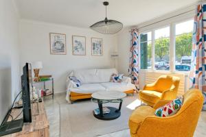 ein Wohnzimmer mit Sofa, Sesseln und Fernseher in der Unterkunft Maison Ker Hélène sur grand jardin in Guérande
