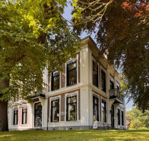 a large white house with large windows at Villa Abbekerk - Bed & Breakfast in Abbekerk +62 photos