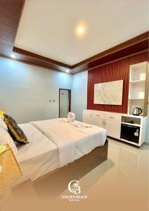a bedroom with a large bed and a kitchen at Golden Beach Hotel Sekotong in Pulau Gilipoh