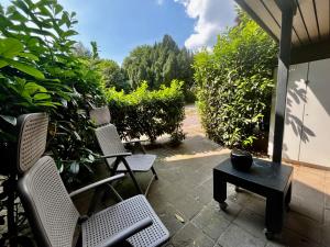two chairs and a table on a patio at appartement op de begane grond met terrasje in Groesbeek
