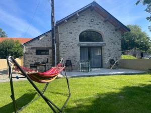 a hammock in front of a stone house at Nature en ville in Saint-Herblain
