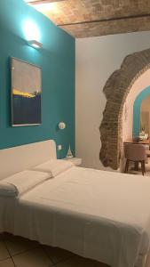 a bedroom with a white bed and a blue wall at Barbarossa Sea Room in Termoli