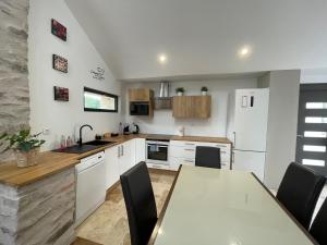 a kitchen with a table and a white refrigerator at Nature en ville in Saint-Herblain +6 photos
