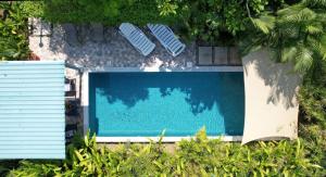 Una piscina con dos tumbonas al lado. en Apartment with large terrace and garden view, en Uvita 27 fotos más