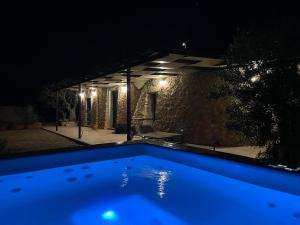 a blue swimming pool at night with a patio at TRULLO VISTA MARE - Mini piscina riscaldata con idromassaggio in Marina San Gregorio