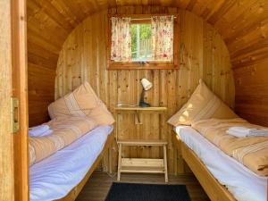 two beds in a log cabin with a window at Apart-Hotel Kastanienhof in Dannenfels