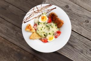 un plato blanco de comida con huevos y tostadas en Гук готельно-ресторанний комплекс, en Bukovel