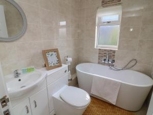 un bagno con vasca, WC e lavandino di James Ville Marina Lodge 10 a Brigg