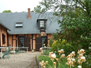 a house with a garden with flowers in front of it at Les Granges Du Bout De La Ville in Montville