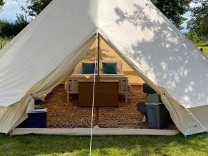 a tent with a bed and a desk in it at Fords Farm Glamping & Farm House in Oswestry +25 photos