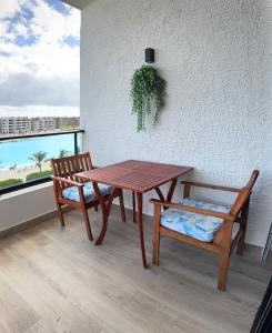 einen Holztisch, eine Bank, einen Tisch und einen Stuhl in der Unterkunft Paradise Apt in Punta Cana in Punta Cana