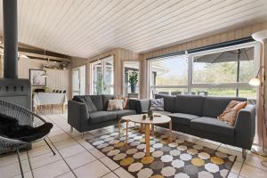a living room with a couch and a table at Odsherred Feriehus in Asnæs +10 photos