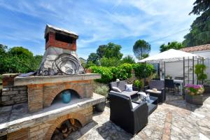 een stenen open haard in een tuin met een patio bij Apartments Villa Herak in Poreč
