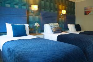 a hotel room with two beds with blue covers at The Newgrange Hotel in Navan