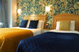 a hotel room with two beds with blue pillows at The Newgrange Hotel in Navan