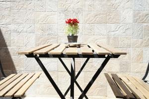 a table with a vase with a red flower on top at La Riva del Sonno in Rivisondoli