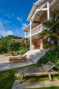 een huis met twee houten banken in de tuin bij Lagrange Vacances - Eden Parc Golf in Lacanau-Océan