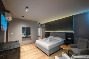 a bedroom with a bed and a couch and a table at Ersa Luxury Rooms in Sarandë