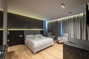 a bedroom with a white bed and a desk and chair at Ersa Luxury Rooms in Sarandë