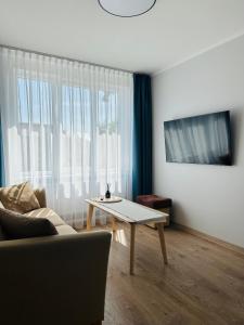 a living room with a table and a couch at NB Apartamentai in Palanga