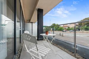 a table and chairs on a balcony with a view of a street at Luxury 2-Bed with Balcony & Secure Parking in Leeds