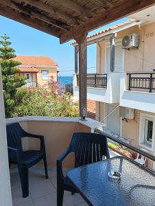 a balcony with a table and chairs and the ocean at ΤΑ ΩΡΑΙΑ ΤΗΣ ΑΘΗΝΑς in Skala Mistegnon