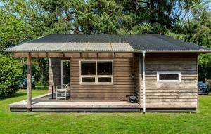 a small cabin with a solar roof on the grass at 1 Bedroom Awesome Home In Væggerløse in Marielyst
