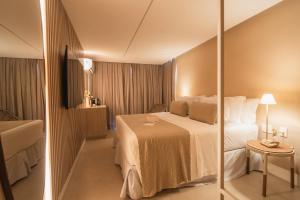 a hotel room with a bed and a mirror at Pousada Filó in Fernando de Noronha +69 photos