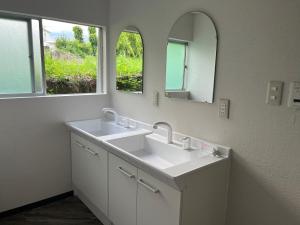 a white bathroom with two sinks and two mirrors at 竹の宿 2025年リノベ古民家 最大16名宿泊対応 湖まで徒歩4分 in Fujikawaguchiko +26 photos