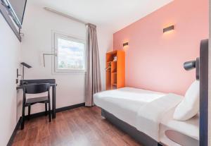 una camera da letto con un letto, una scrivania e una sedia di B&B HOTEL Strasbourg Nord Mundolsheim a Mundolsheim