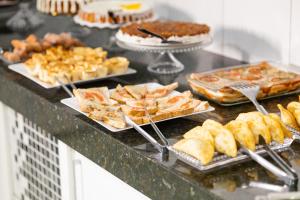 a buffet with many different types of pastries and desserts at Hotel Village in Pato Branco