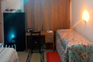 1 dormitorio con escritorio, 1 cama y escritorio en hspedagemfuncional, en Porto Alegre