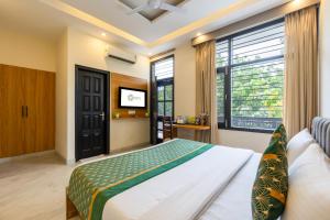 a bedroom with a large bed and a tv at OPO Essential, Sector 21 Gurgaon in Gurgaon +72 photos