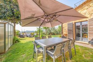 a table and chairs under an umbrella in a yard at B&B Al Vecchio Forno in Montepulciano