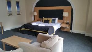 a hotel room with a bed and a chair at Northern Hotel in Brechin +31 photos