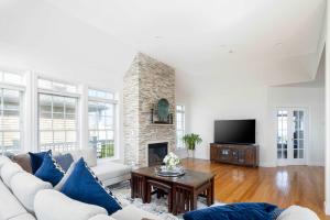 un soggiorno con divano e camino di Dunecrest by RoveTravel - Family Oceanfront with Heated Pool a Westhampton Beach