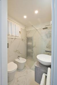 a white bathroom with a sink and a toilet at Nice Stresa - Appartamento Isola Madre in Stresa