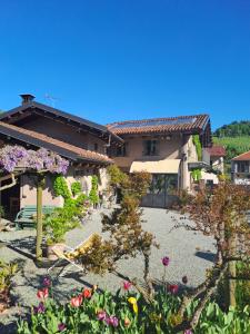 a garden in front of a house with flowers at Il giardino di fronte in Saluzzo