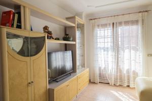 a living room with a flat screen tv in a cabinet at Brisa de Agaete in Puerto de las Nieves