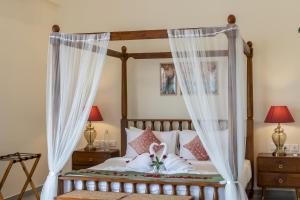 - une chambre avec un lit à baldaquin et des oreillers dans l'établissement Summerville · Luxurious 3bhk villa in Arpora, à Goa 34 autres photos