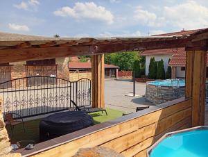 a deck with a bench and a swimming pool at Bohemica Apartman 4 in Kouřim
