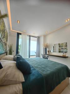 a bedroom with a large green bed and a window at Luxury Panorama View with a Pool in Sarandë