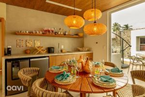 a kitchen with a wooden table and chairs in a kitchen at Naluum Residence Alto Padrão em Milagres By Qavi in Passo de Camarajibe