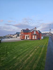 a house with a green lawn in front of it at Atlantic Sea View in Portstewart