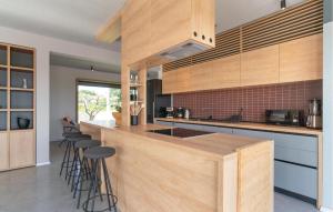 une cuisine avec des placards en bois et des tabourets de bar dans l'établissement Awesome Home In Bukori, à Baldaši