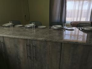 a counter with plates and glasses on top of it at Dees B and B in Rustenburg