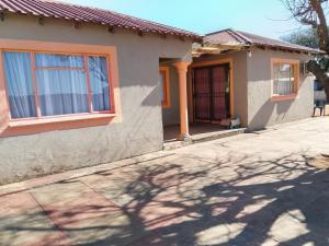 a house with a shadow of a tree at Dees B and B in Rustenburg