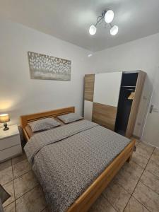 a bedroom with a bed and a refrigerator at Apartman Bepino terasa&parking in Pirovac